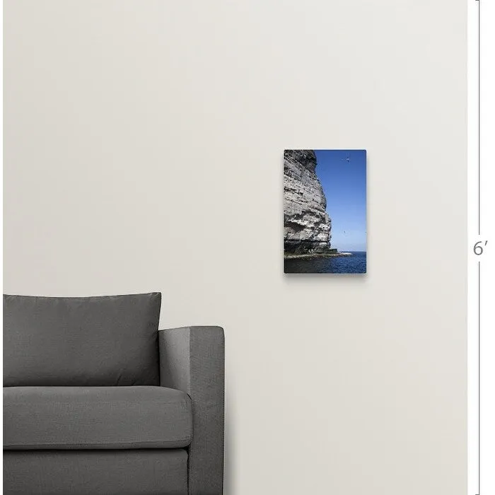"a tall rock face on the water's edge" Canvas Wall Art