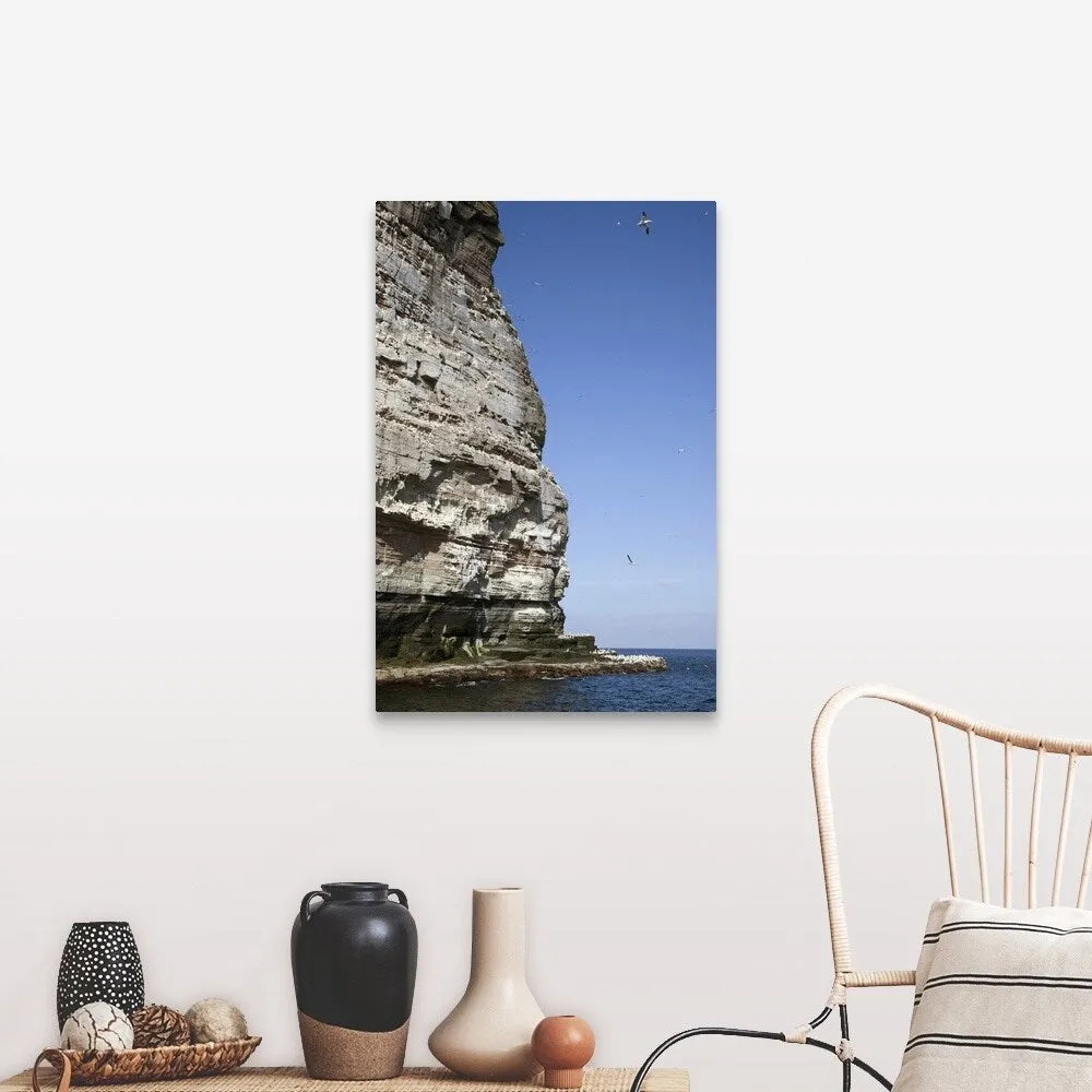 "a tall rock face on the water's edge" Canvas Wall Art