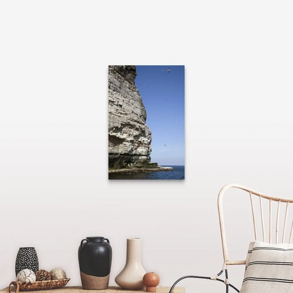 "a tall rock face on the water's edge" Canvas Wall Art